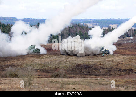 Soldiers assigned to Bravo Battery, 1 Battalion, 147 Field Artillery Regiment, South Dakota Army National Guard, fire rockets from M270A1 Multiple Launch Rocket Systems during exercise Dynamic Front 19 at Grafenwoehr Training Area, Germany, March 6, 2019. Exercise Dynamic Front 19 includes approximately 3,200 service members from 27 nations who are observing or participating from Grafenwoehr Training Area, Germany; Riga, Latvia; and Torun, Poland; during March 2-9, 2019. Dynamic Front is an annual U.S. Army Europe exercise focused on the readiness and interoperability of U.S. Army, joint servi Stock Photo