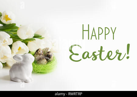 Easter concept. White tulips, quail eggs in nest on white. Space for text. Stock Photo