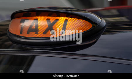 Taxi sign on the roof of a car at night Stock Photo