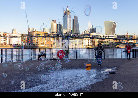 LONDON, UK – Dec 13, 2018: Performer blowing soup bubbles on beautiful sunny day on the bank of River Thames London Stock Photo