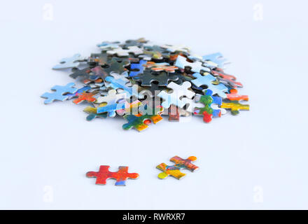 Cardboard multicolored puzzles on a white background. Close-up. Stock Photo