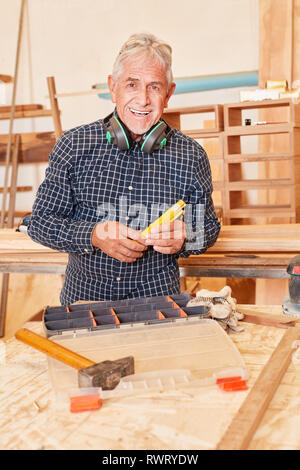 Senior man as a successful craftsman at the workbench in his joinery Stock Photo