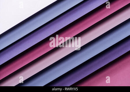 bright blue, white, pink, burgundy and purple sheets of paper on pink background Stock Photo