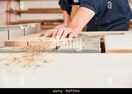 Craftsman saws wood with the circular saw in a carpentry or carpentry workshop Stock Photo