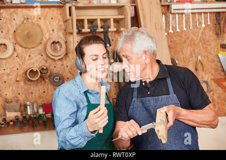 Craftsman apprentice and carpenter masters measure wood with caliper Stock Photo