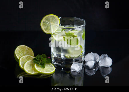 Mojito summer beach refreshing tropical cocktail in glass with soda water, lime juice, mint leaves, sugar, ice and rum. Fresh summer cocktail, sliced  Stock Photo