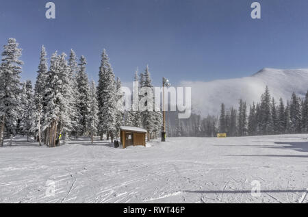 Hut in the winter forest during a snowfall. Colorado, USA Stock Photo