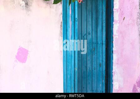 Blue wooden door with a pink painted wall of a maldivian house (Ari Atoll, Maldives) Stock Photo