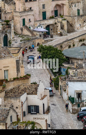 MATERA, ITALY - AUGUST 27, 2018: Warm scenery summer day high angle close-up street view of amazing ancient town of the famous Sassi with wonderful bu Stock Photo