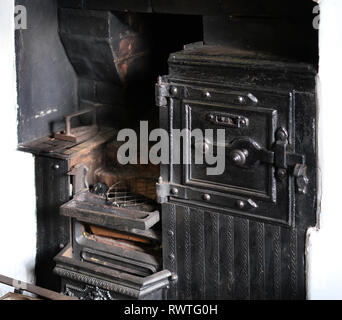 Old cooking and heating range in farmhouse kitchen display. Stock Photo