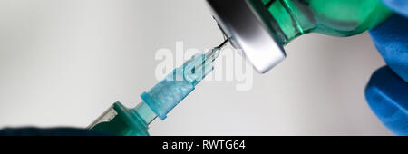 Physician injector arms in sterile uniform holding syringe Stock Photo