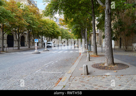 PARIS, FRANCE - JULY 23, 2017: Empty parisian street and sidewalk with green trees in a summer day in Paris, France Stock Photo