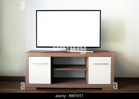 Big flat LCD Television with a blank screen on a wooden tv stand Stock Photo