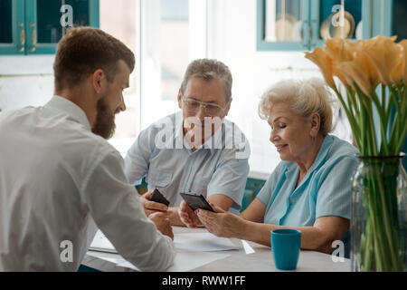 Senior couple making a decision with help of an advisor. Retirement, golden years and financial planning. Stock Photo