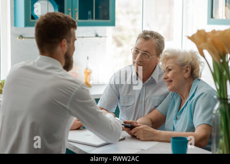 Seniour couple meeting an advisor to plan investments. Financial planning and guidance concept. Stock Photo
