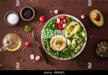 healthy vegan lunch bowl with avocaco cucumber hummus peas radish Stock Photo