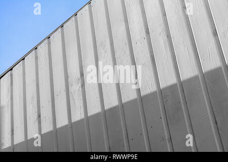 White wooden wall with shadow area under blue sky, abstract vertical background photo Stock Photo