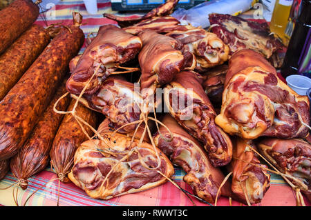 Homemade sausages smoked and dried and other products stand on the table for sale. Stock Photo