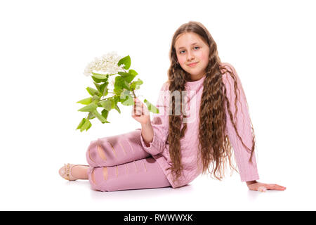 Smiling girl 10-11 years old in a pink suit holding white lilac in her hands. Isolation on a white background Stock Photo