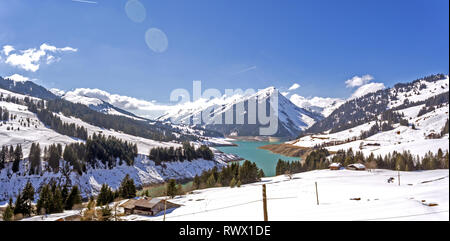 Lac de l'Hongrin is a reservoir in Vaud, Switzerland. Snowy mountain peaks surround the high alpine man made lake. Stock Photo