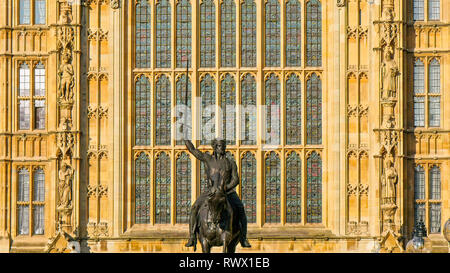 A monument of a man riding a horse infront of the Palace of Westminster in London Stock Photo