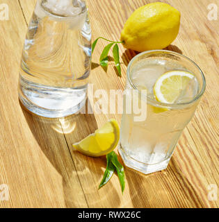 Mineral Water with Lemon on wooden Background in Summertime Stock Photo