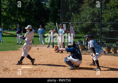 View of a baseball game in New York's Central Park through a chainmail fence. Catcher s view of baseball game Central park New York City. Central Park Stock Photo