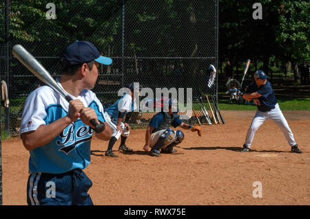 View of a baseball game in New York's Central Park through a chainmail fence. Catcher s view of baseball game Central park New York City. Central Park Stock Photo