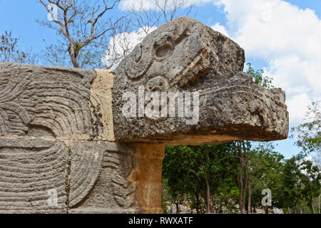 Close up of the head of a mayan carved stone snake with geometric patterns on the body from Chechen Itza Stock Photo