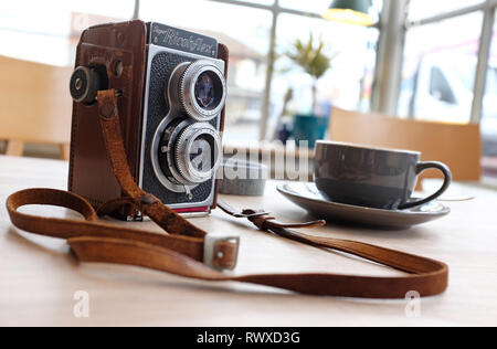 retro vintage camera on table top in cafe interior Stock Photo