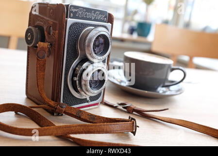 retro vintage camera on table top in cafe interior Stock Photo