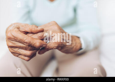 Heartbroken elderly woman holding he husbands wedding ring Stock Photo
