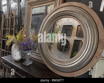 Mirrors in wooden frames on the wall are reflected in each other. Stock Photo