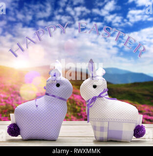 Two Easter yellow bunnies with happy easter text. Easter holiday concept. Stock Photo