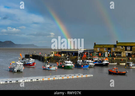 Lyme Regis, Dorset, UK.  7th March 2019. UK Weather.  A rainbow arches over the Cobb Harbour at the seaside town of Lyme Regis in Dorset on an afternoon of sunshine and showers.   Picture Credit: Graham Hunt/Alamy Live News Stock Photo