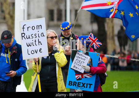 Anti-Brexit demonstrators are seen with placards protesting outside the Houses of Parliament. Stock Photo
