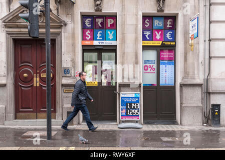 Beijing, China. 6th Mar, 2019. A man passes by a money exchange shop near the Bank of England in London, March 6, 2019. As Britain is set to leave the European Union (EU) on March 29, UK Finance firms have been preparing for a 'no-deal' scenario that they believe would be 'catastrophic' for the nation's economy. Credit: Stephen Chung/Xinhua/Alamy Live News