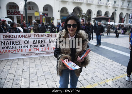 Thessaloniki, Greece. 8th Mar, 2019. A woman shares brochures during a protest. Due to International Women's Day women of the Hellenic Women Federation demonstrated at the center of the city, demanding equal rights with men in the labor sector and improvement on the working conditions of working mothers. Credit: Giannis Papanikos/ZUMA Wire/Alamy Live News Stock Photo