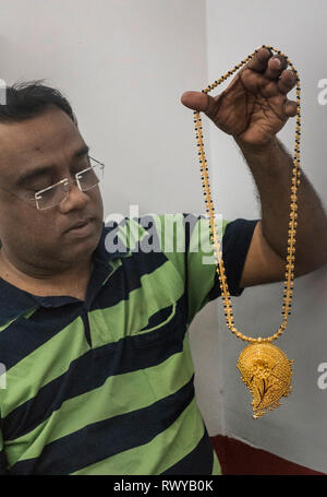 (190308) -- KOLKATA, March 8, 2019 (Xinhua) -- A worker shows gold jewellery at a workshop in Kolkata, India, March 8, 2019. Indian jewellery industry plays an important role in the economy, accounting for 7 percent of GDP and 14 percent of merchandise exports and provides direct employment to 5 million people. (Xinhua/Tumpa Mondal) Stock Photo