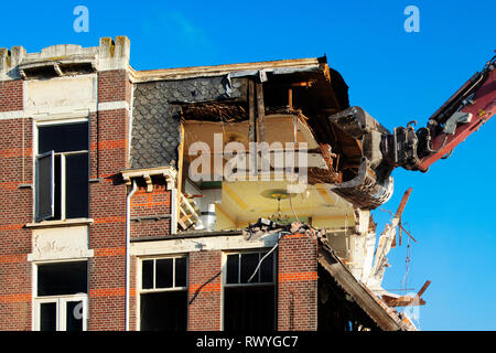 Excavator destroying an old residential building house, old life new life. Renovation concept. - Image Stock Photo