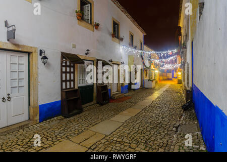 Evening view of alleys in the old town, with Christmas decorations, in Obidos, Portugal Stock Photo