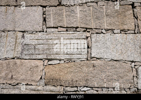 Block retaining wall made of big granite stones Dry masonry. Construction background Stock Photo