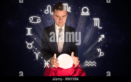 Young handsome astronaut looking for inspiration in his crystal magic ball  Stock Photo