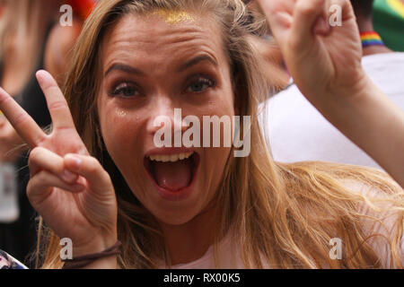 Young girl making love sign with fingers at the annual Pride Parade LGBT. Impressions from gay and lesbians participating in the Gay Pride Parade with Stock Photo