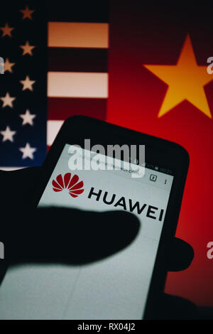 Huawei logo on its website is shown on a smartphone display, United States flag and People's Republic of China flag unfocused on background Stock Photo