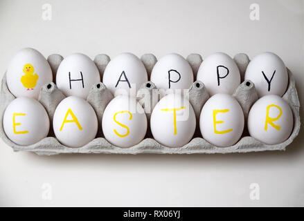 Happy Easter greetings with this fun box of eggs on white background Stock Photo