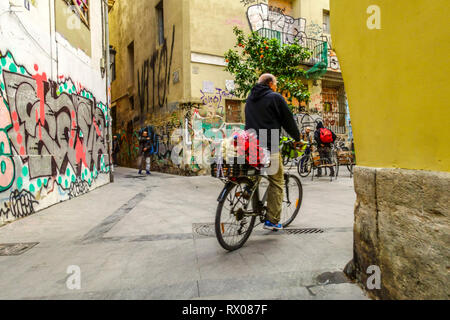 Man on a bicycle is delivering flowers, El Carmen district, Valencia Old Town, Spain Stock Photo