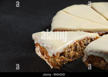 carrot cake with icing on dark back close up Stock Photo