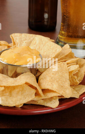 Closeup of tortilla chips with a glass of beer in the background Stock Photo