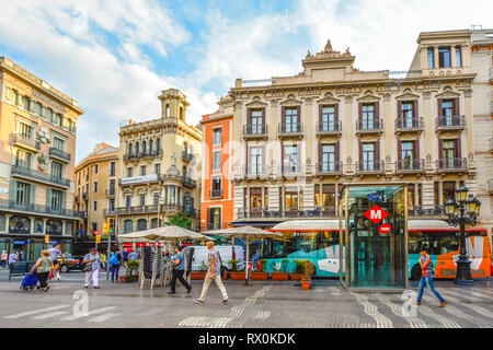 Pedestrians walk the colorful street La Rambla past buses and shops in Barcelona Spain Stock Photo